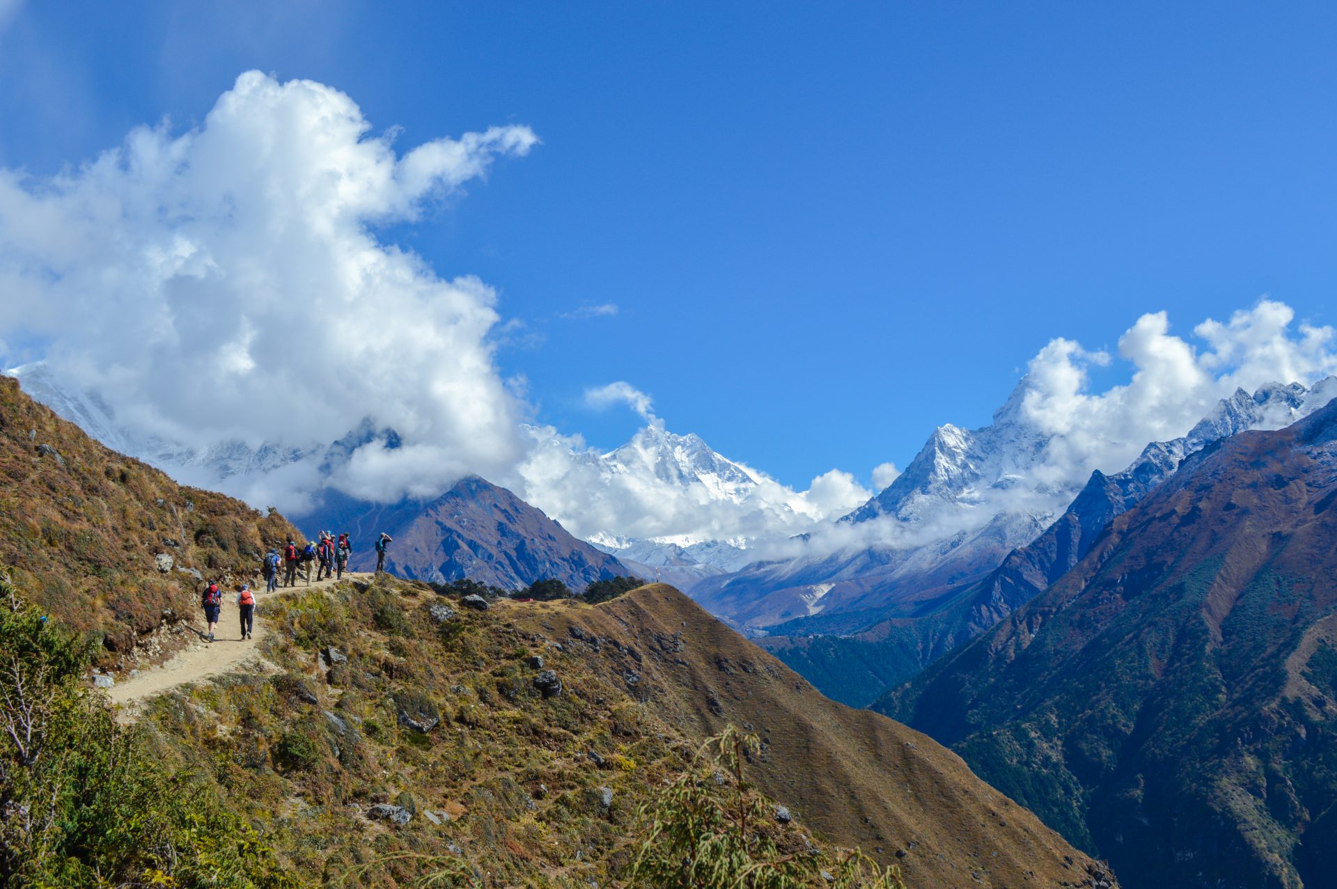 How long does it take to trek to the Everest base camp? 2 Windhorse Tours D3.14 A view at Shyangboche trekkers walking on the road and on the front having view of the mountain Range including Mt. Everest and Aamadeblam Windhorse Tours